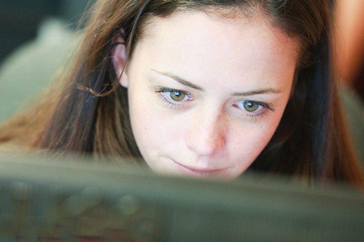 Keystone College student reads on computer